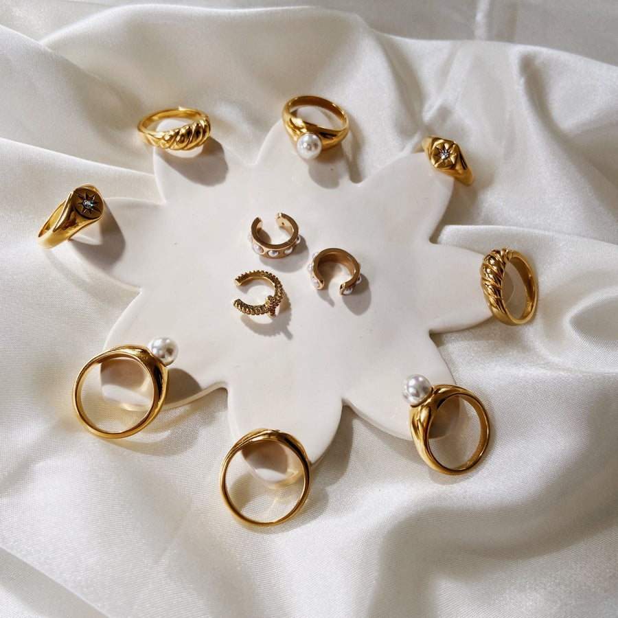 gold rings display on white flower plate