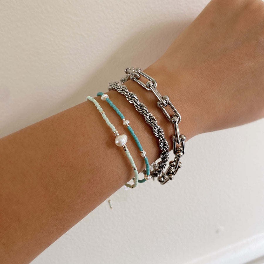 layered beaded bracelets in silver, mint and turquoise on wrist