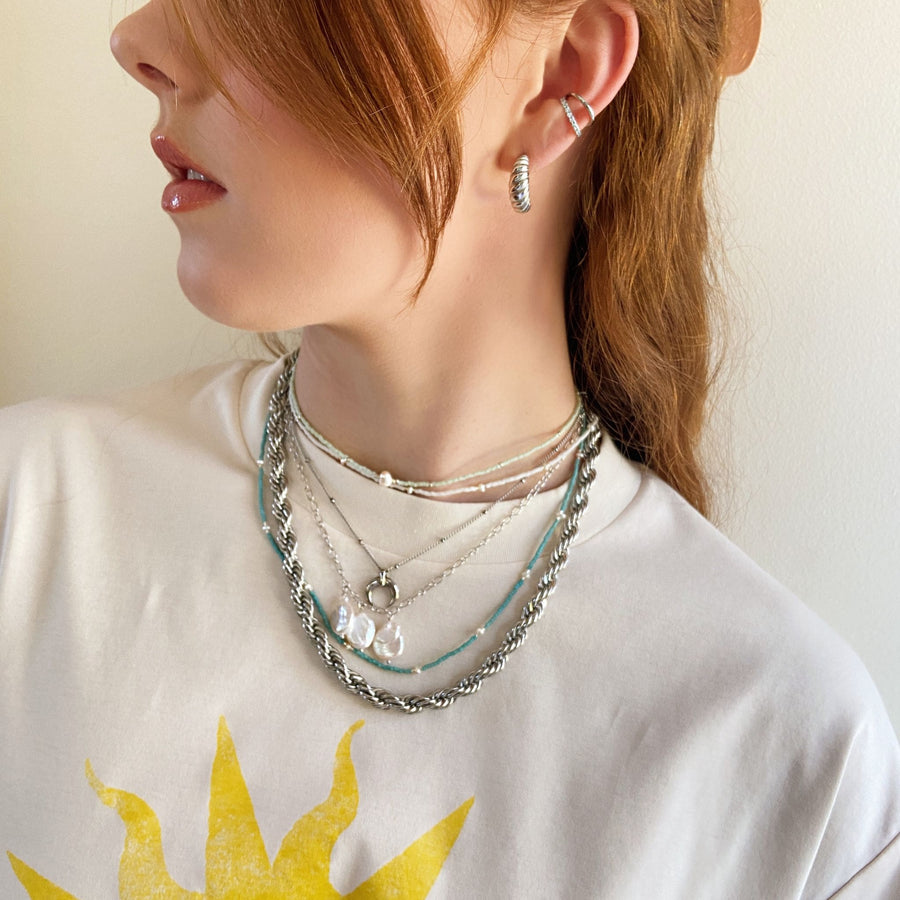 girl wearing silver chain stack with tee