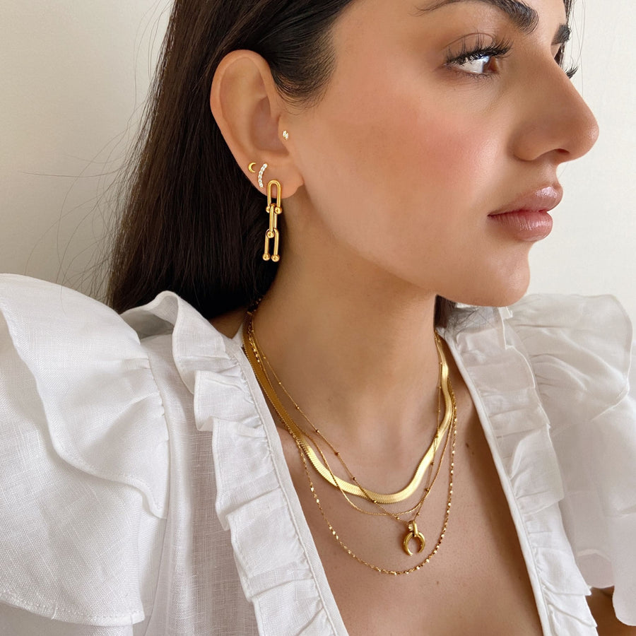 edgy gold jewellery layered over white top
