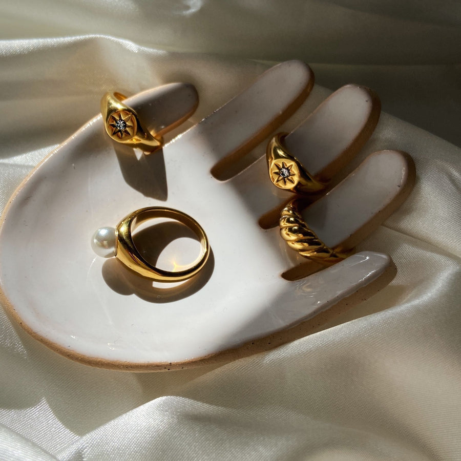 Gold rings display on jewellery dish shaped like a hand