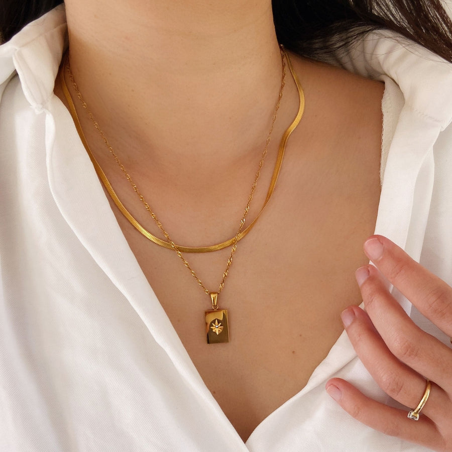 layered gold necklaces worn with white shirt
