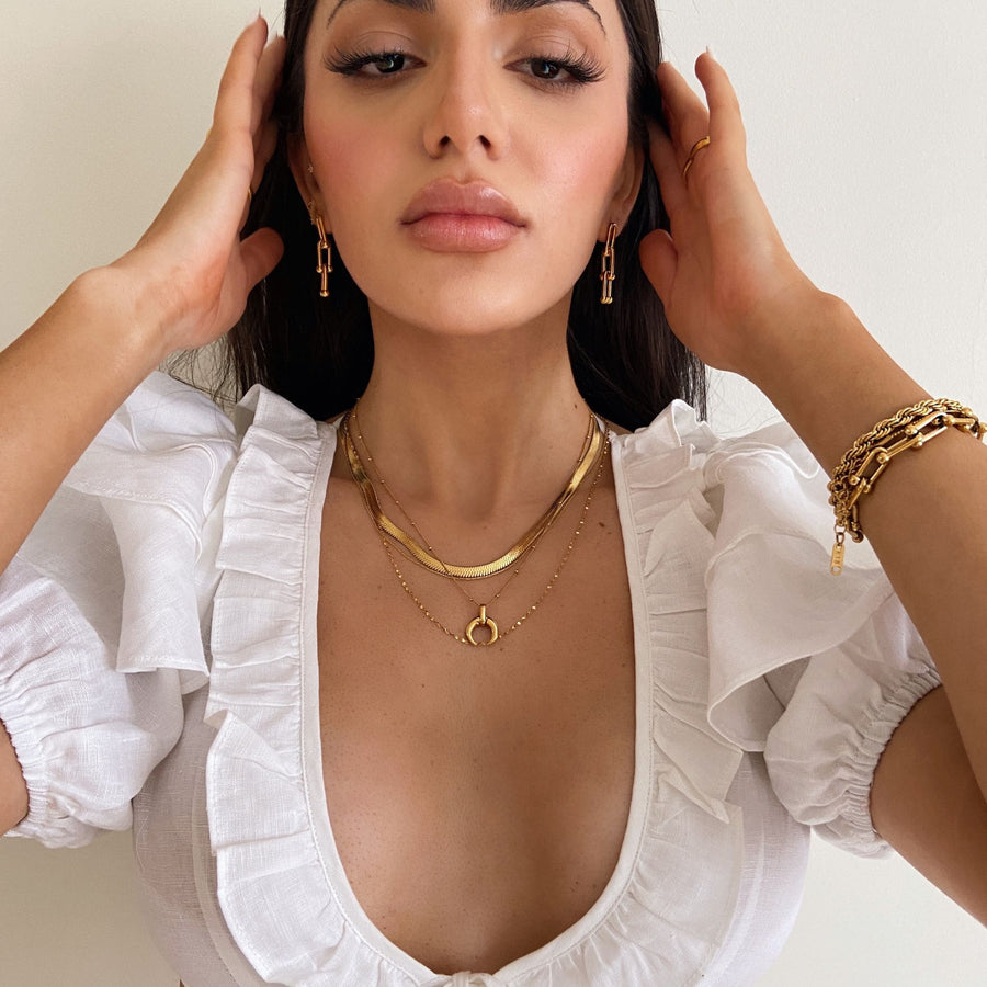 woman wearing sexy gold jewellery and white top