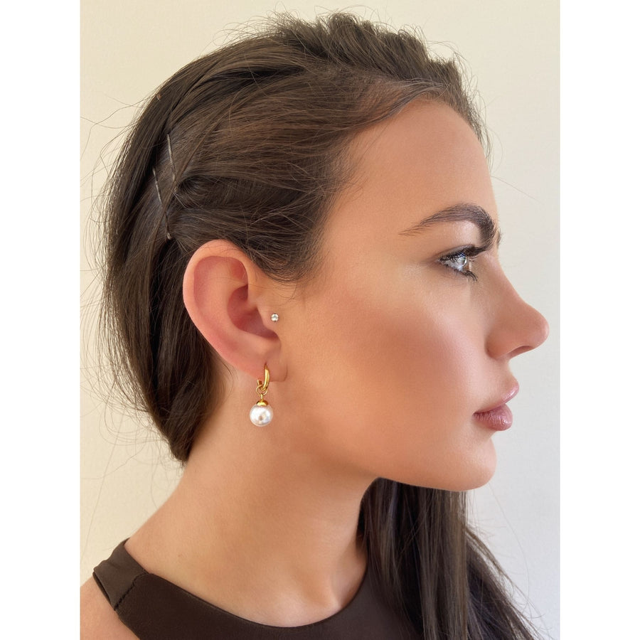 woman wearing simple pearl hoop earring