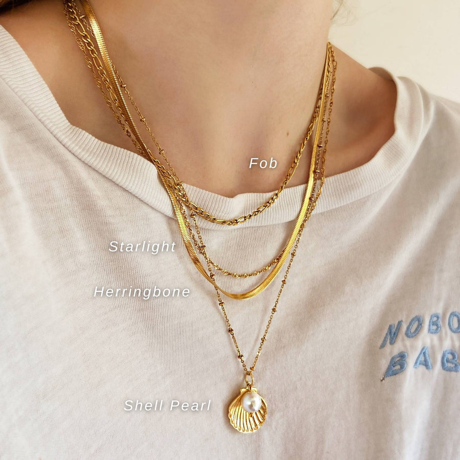 gold stacking necklaces with white tee